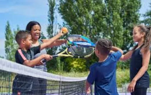 a group of people playing tennis