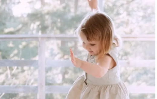 a little girl standing in front of a window