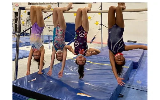 a group of people doing a handstand on a trampoline