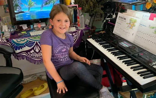 a girl sitting on a piano