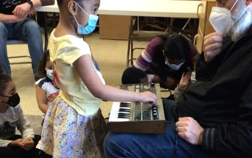 a group of people playing a piano