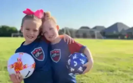 a couple of girls holding a ball