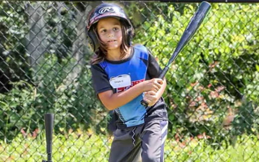 a young girl playing baseball