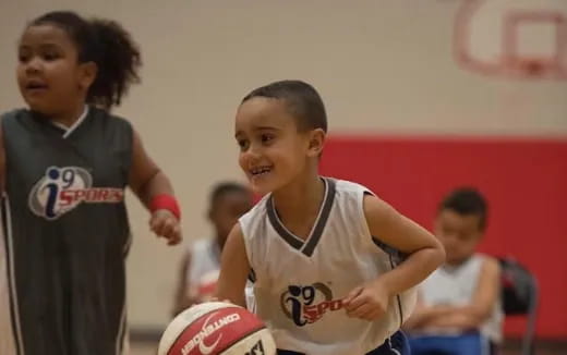 a few young children playing basketball