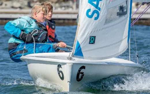 a couple of boys on a sailboat