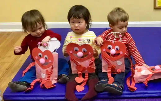 a group of children sitting on a blue mat with toys