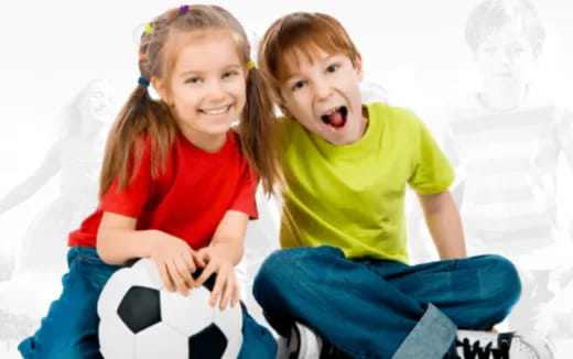 a couple of children sitting on a couch and laughing