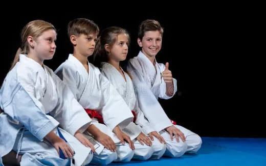 a group of people in white karate uniforms