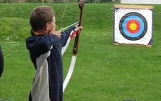 a boy holding a bow and arrow