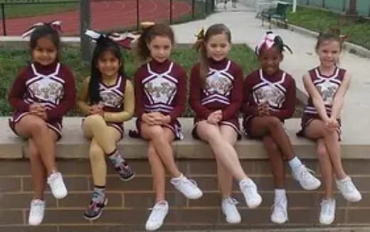 a group of girls sitting on a bench