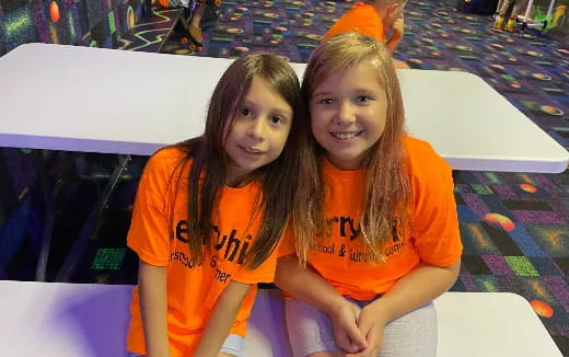 a couple of girls in orange shirts