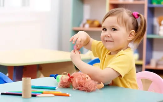 a little girl sitting at a table