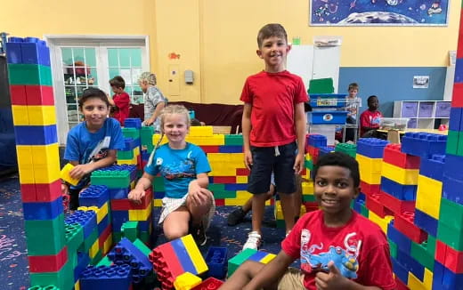 a group of children playing in a room with colorful blocks