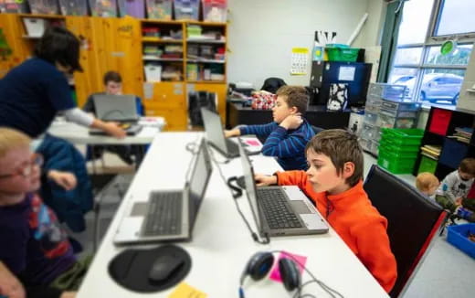 a group of kids using laptops