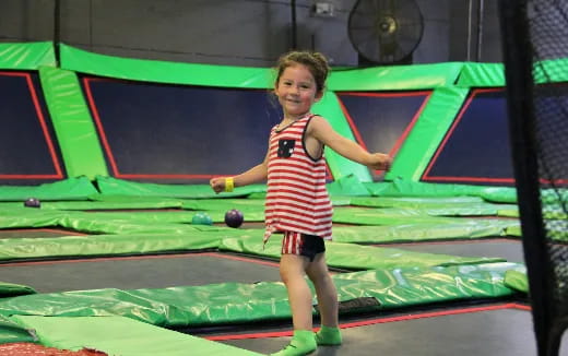 a girl standing on a trampoline