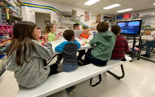 a group of children sitting at desks in a classroom