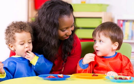 a person and two children eating