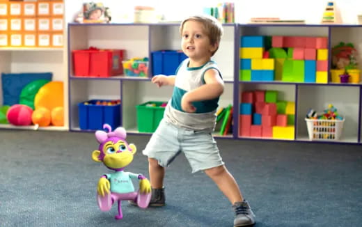 a child standing next to a toy