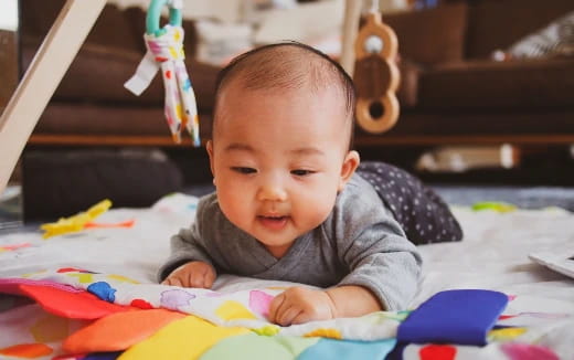a baby lying on a blanket