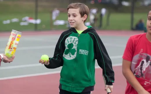 a person holding a tennis racket and a ball