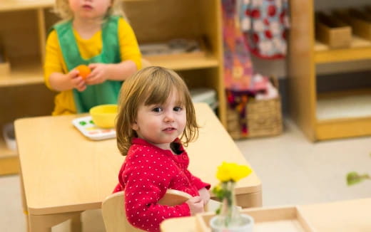 a little girl sitting at a table