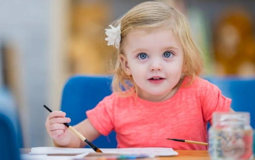 a little girl sitting at a table