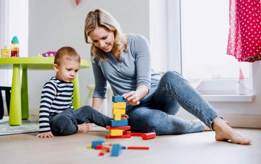 a person and a child playing with toys on the floor