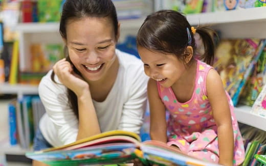 a young girl and a young girl looking at a book