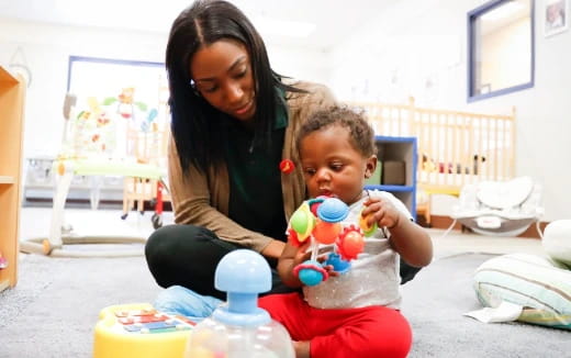 a person and a child playing with toys in a room