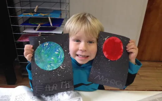 a boy holding a large blue and red ball