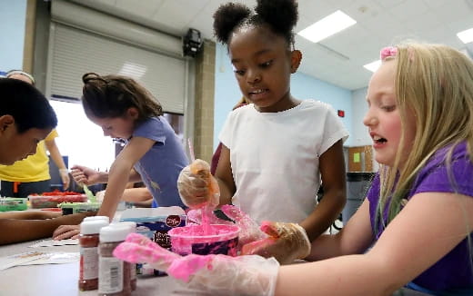 a group of children making a cake