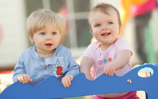 two babies in a blue shopping cart
