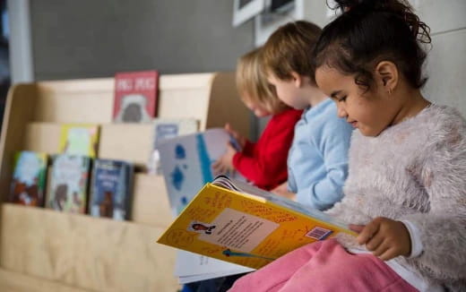 a person reading a book to a young girl