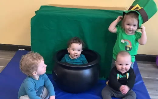 a group of children sitting in black chairs