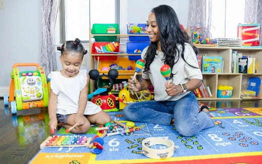 a person and a child playing with toys in a room