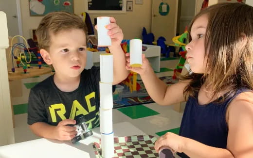 a boy and girl holding up a white object