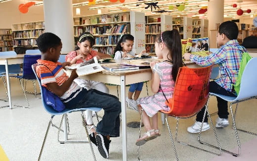 a group of people sitting at a table in a library