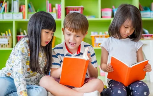 a group of children sitting on the floor reading books
