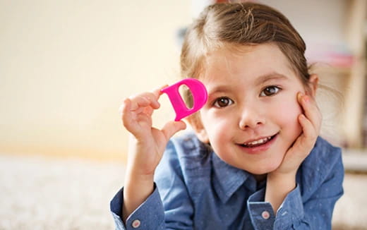 a child holding a pink cup