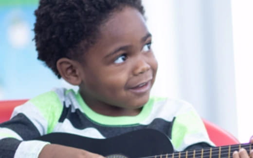a young boy playing a guitar