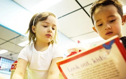 a boy and girl looking at a book