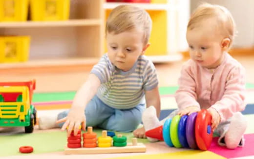 a couple of babies playing with toys