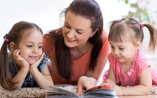 a person and two children looking at a tablet