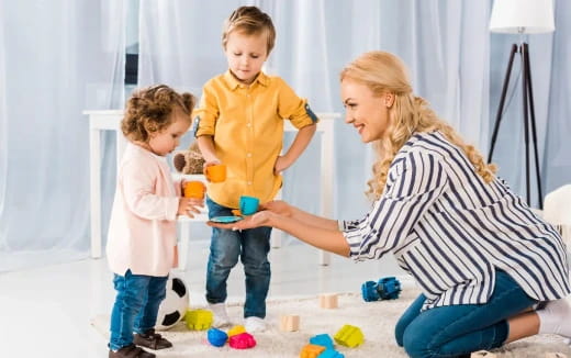 a person and two children playing with toys