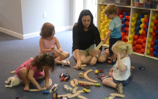a person and several children playing with toys
