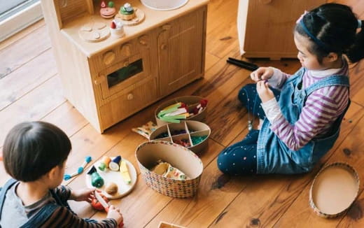 a person and a child sitting on the floor eating from bowls