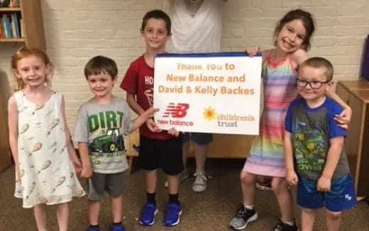a group of children holding a sign