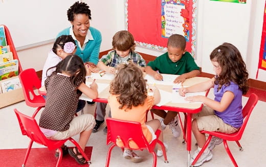 a group of children sitting around a table