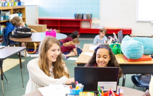 a few young girls working on a laptop