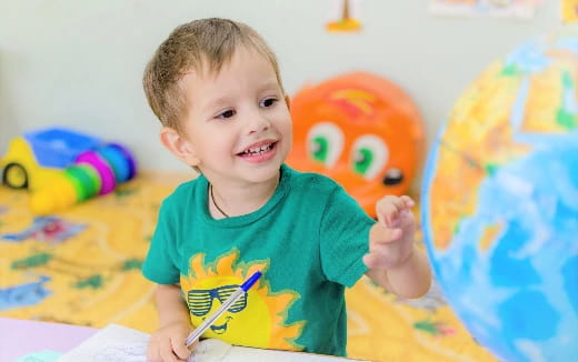 a baby holding a pencil